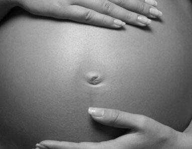 Pregnant woman sitting black and white photo